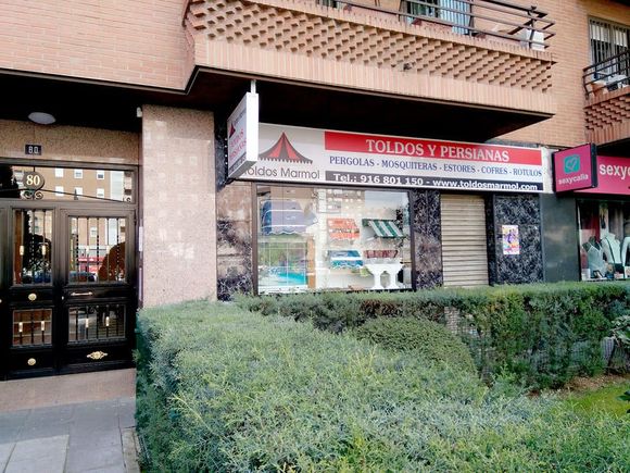 Un escaparate con un cartel que dice toldos y persianas.