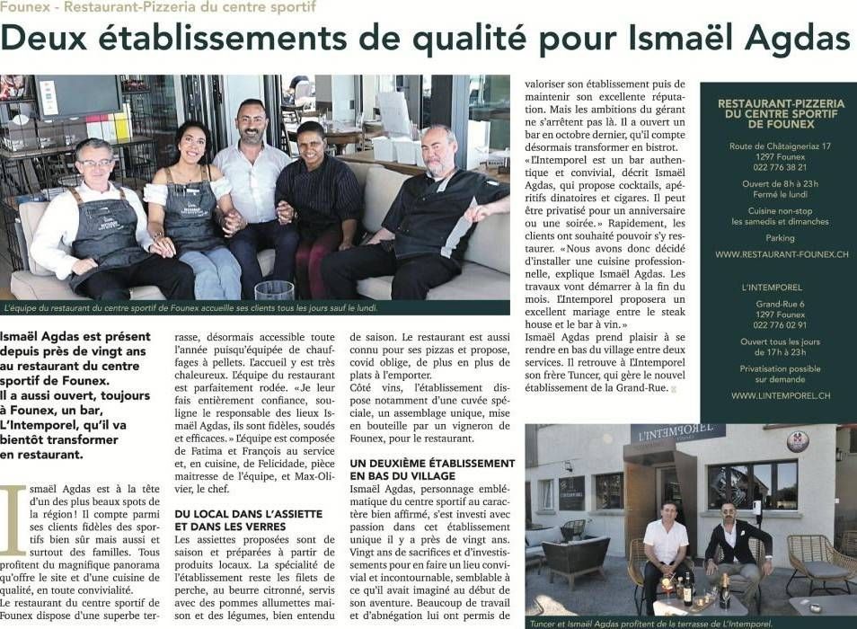 Article de journal avec une photo de groupe de personnes assises à l'intérieur.