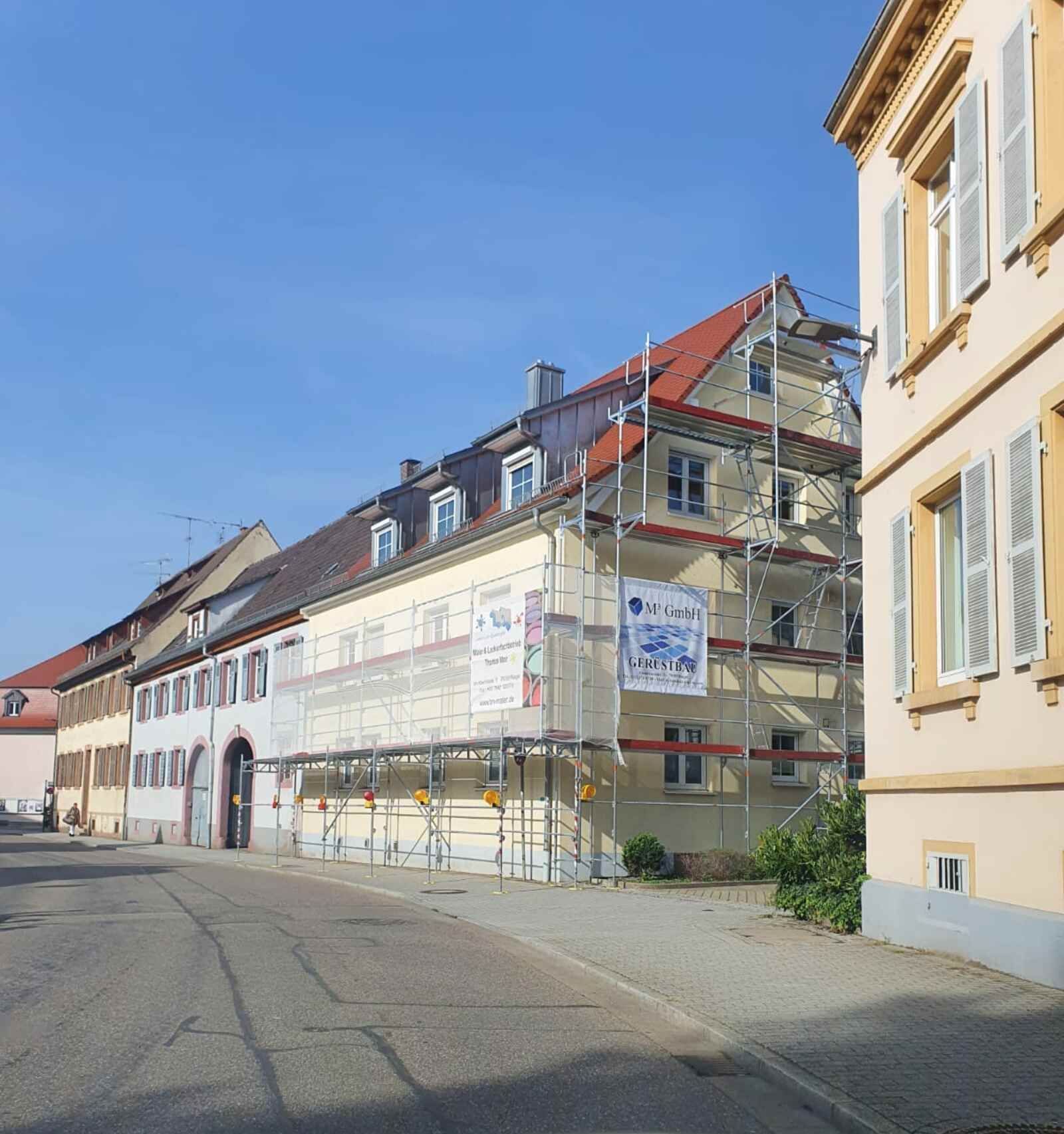 Eine Reihe von Gebäuden mit Gerüsten davor