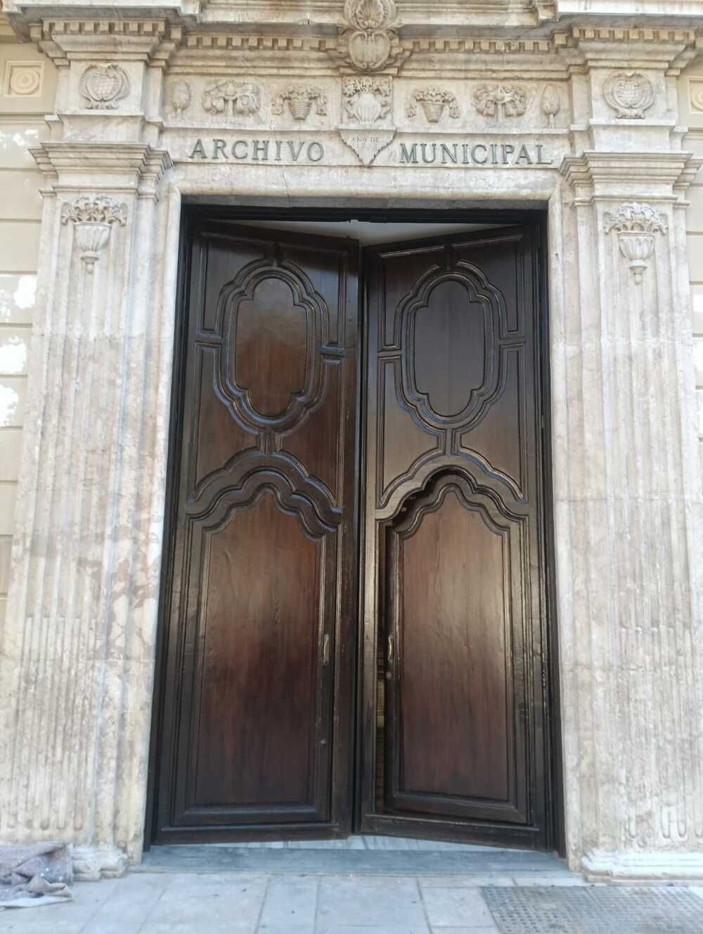 Puertas dobles de madera del Archivo Municipal. Fachada de piedra beige con detalles tallados y la inscripción «ARCHIVO MUNICIPAL».