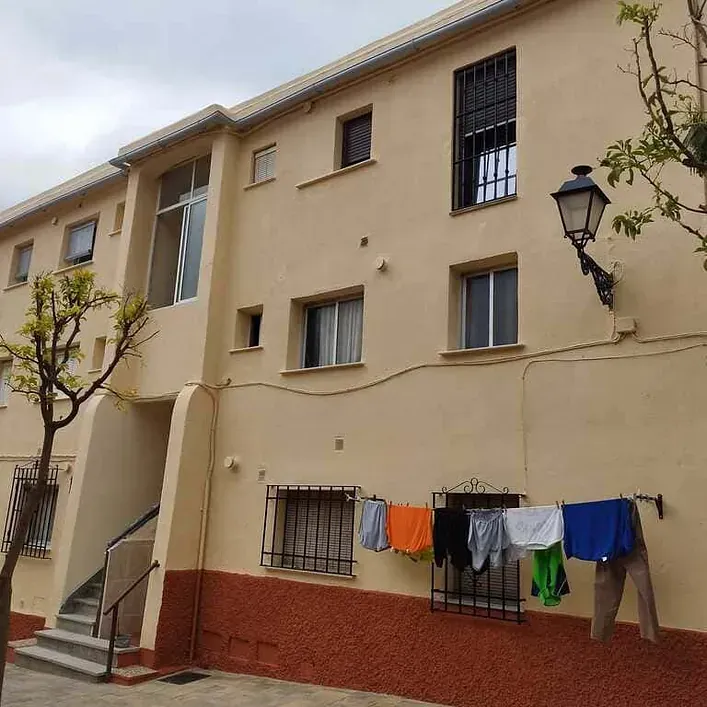 La ropa está colgada en un tendedero fuera de un edificio.