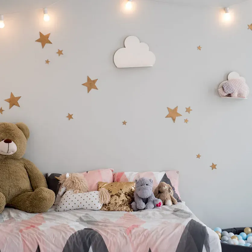 Un oso de peluche está sentado en una cama con animales de peluche.