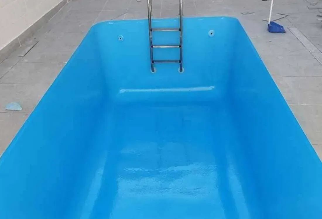 Una piscina azul con una escalera en ella