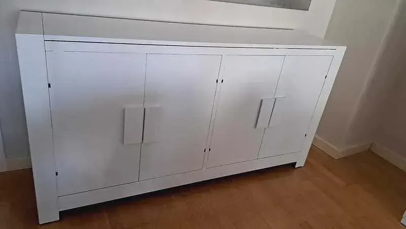 Una terraza de madera con un borde negro se encuentra al lado de un edificio.