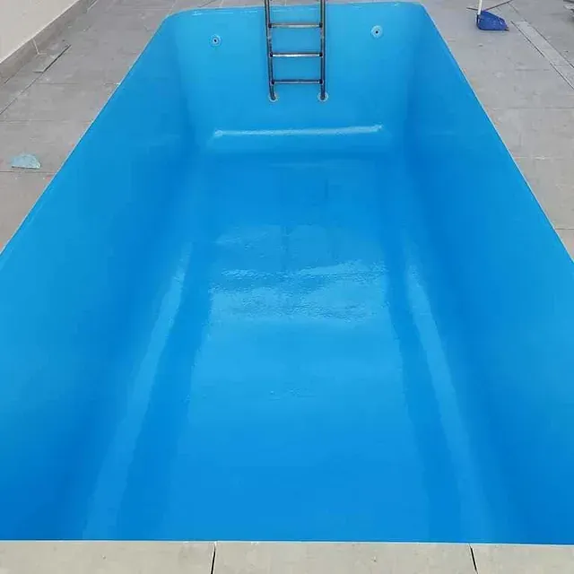 Una gran piscina azul con una escalera en ella.