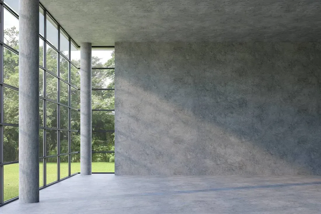 Una habitación vacía con muchas ventanas y una pared de hormigón.