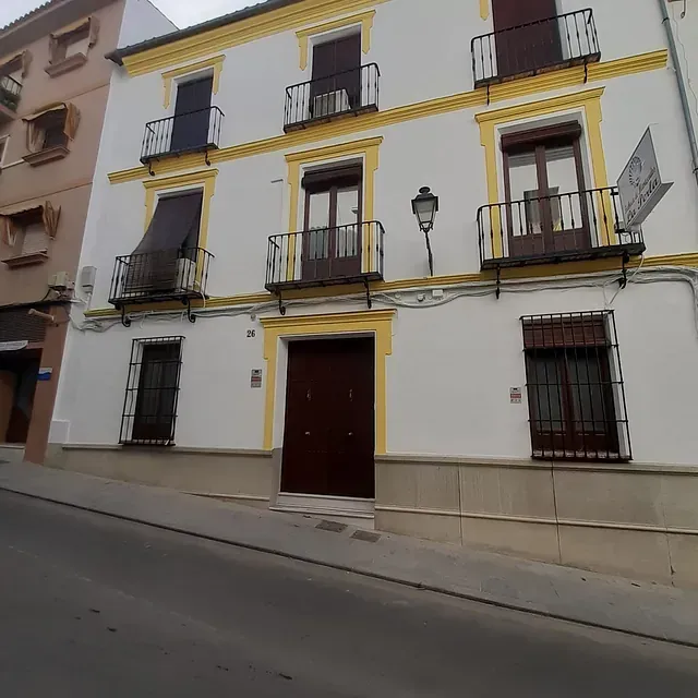 Un gran edificio blanco con molduras amarillas y balcones.
