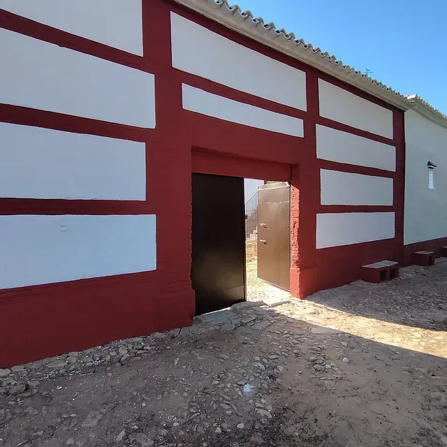 Un edificio rojo y blanco con una puerta negra.