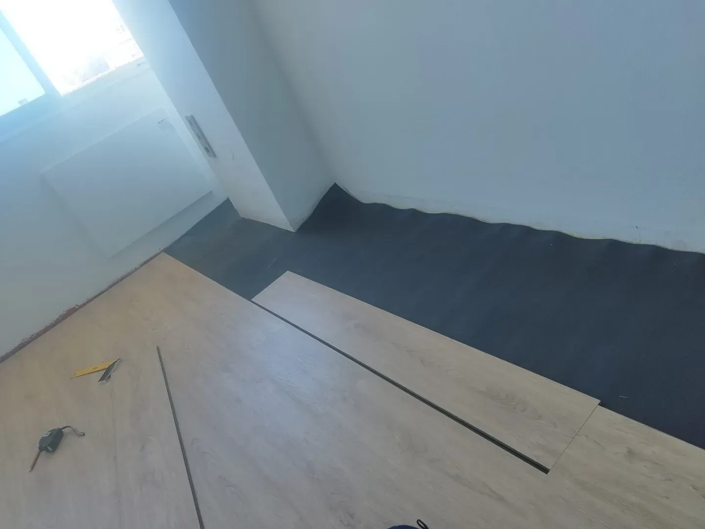 Se está instalando un suelo de madera en una habitación.
