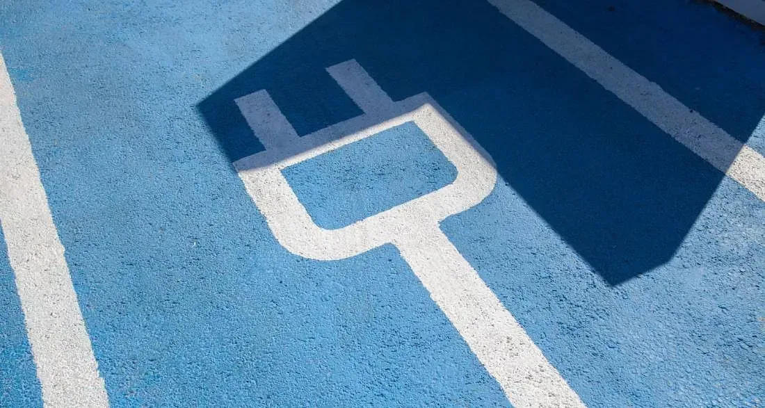 Un primer plano de un estacionamiento azul con una línea blanca y un tapón.