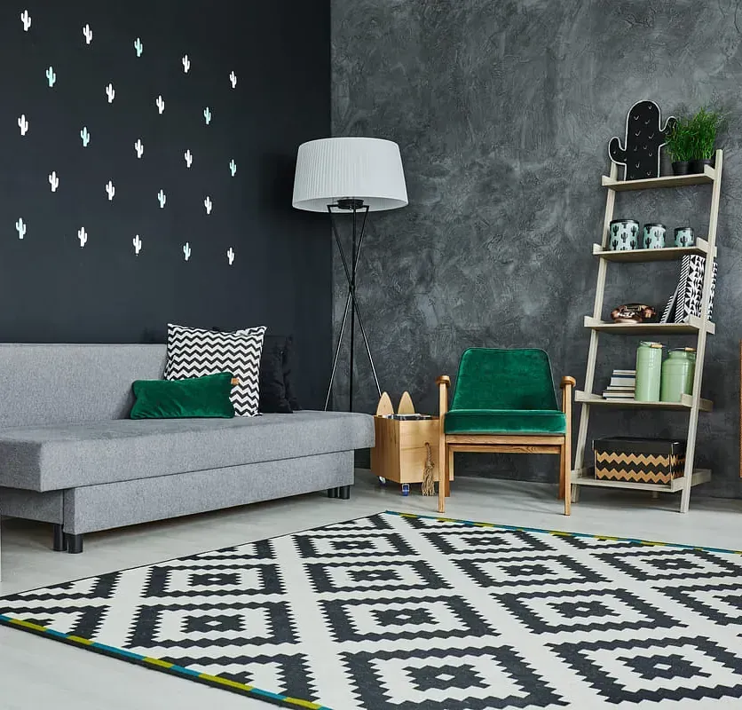 Una sala de estar con un sofá, una silla y una alfombra.