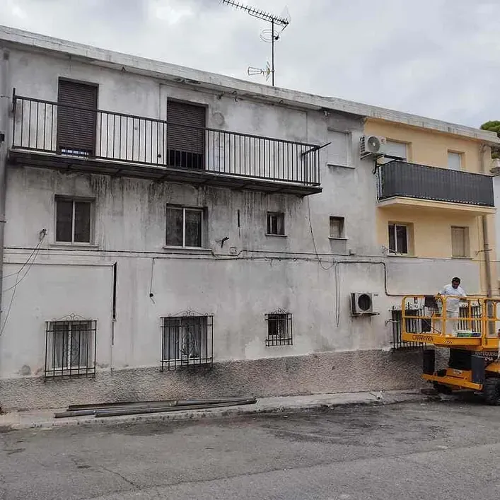 Un hombre en un cubo está trabajando en un edificio.