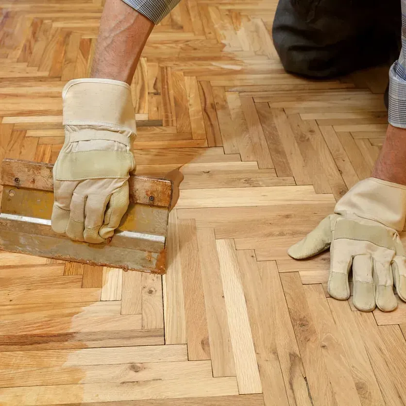 Una habitación con suelo de madera y un martillo en el suelo.