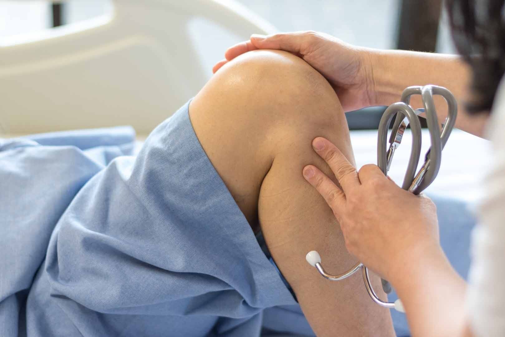 Médecin examinant le genou d'un patient