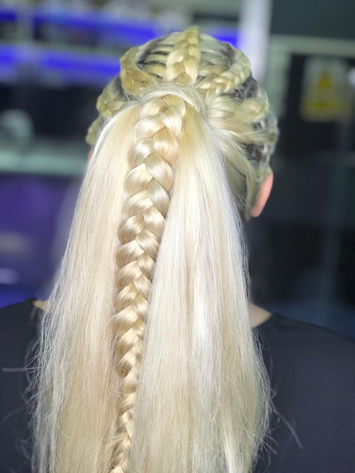 Cabello rubio en trenzas, una trenza larga desde la coronilla y cabello suelto por debajo.