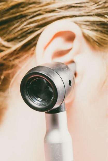 Un otoscopio examinando un oído.