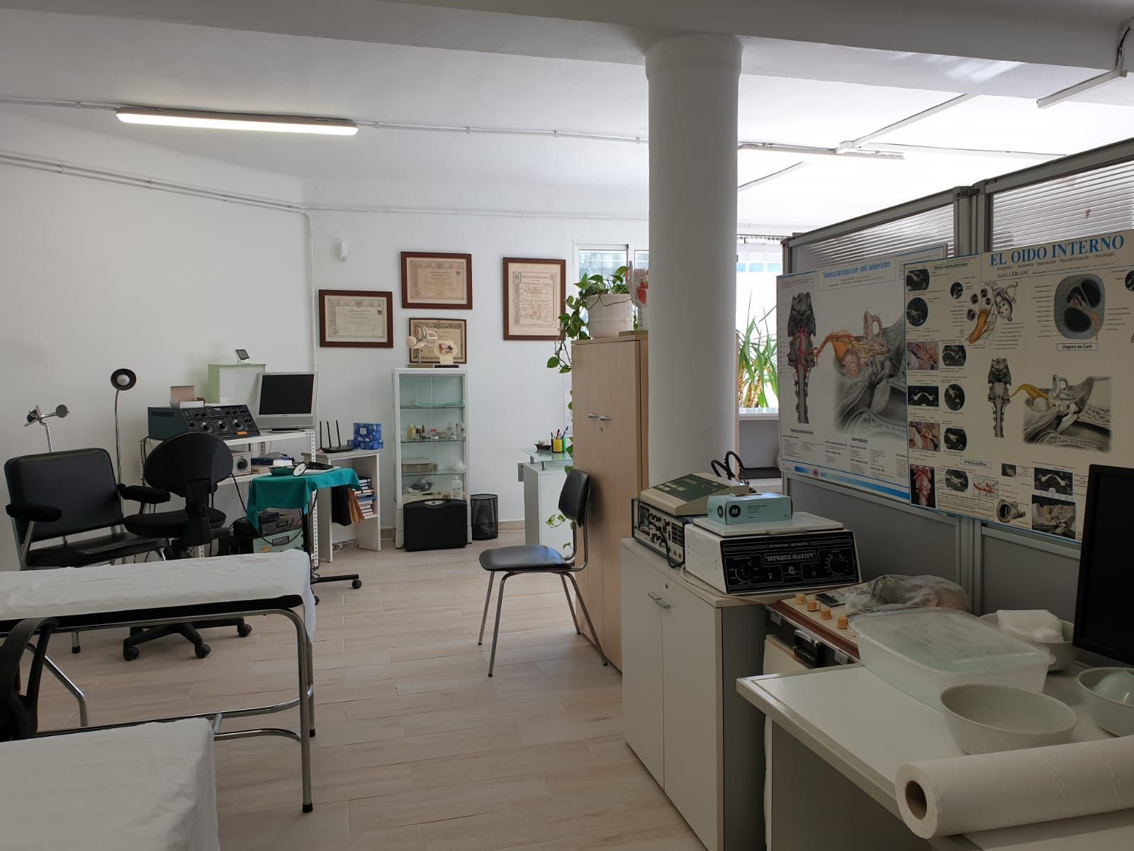 Médico examinando el oído de un paciente con un otoscopio. Guantes azules. Entorno médico.