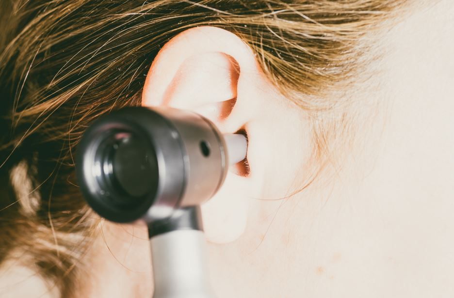 Un otoscopio examina el oído de una persona.