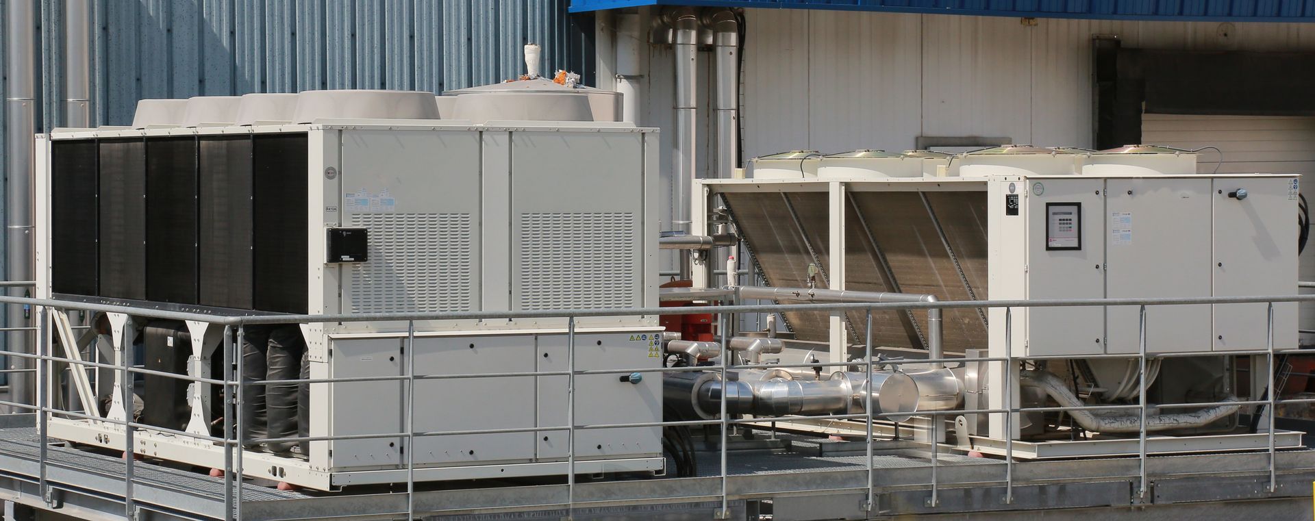 Unités de climatisation industrielles et conduits de ventilation sur le toit d'un bâtiment métallique