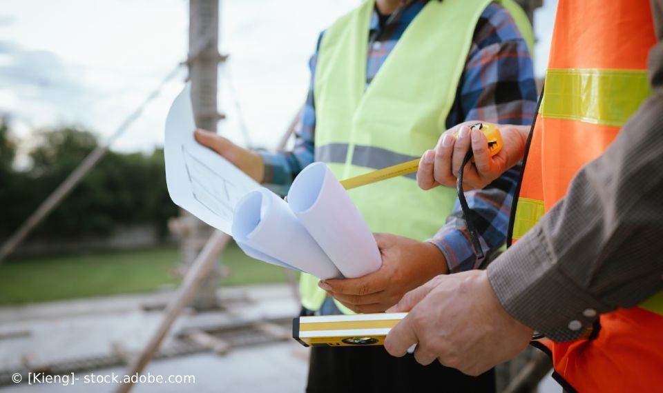 Bauarbeiter prüfen Baupläne auf einer Baustelle