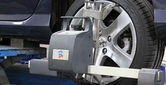 Machine de géométrie des roues mesurant la roue avant d’une voiture dans un atelier de réparation