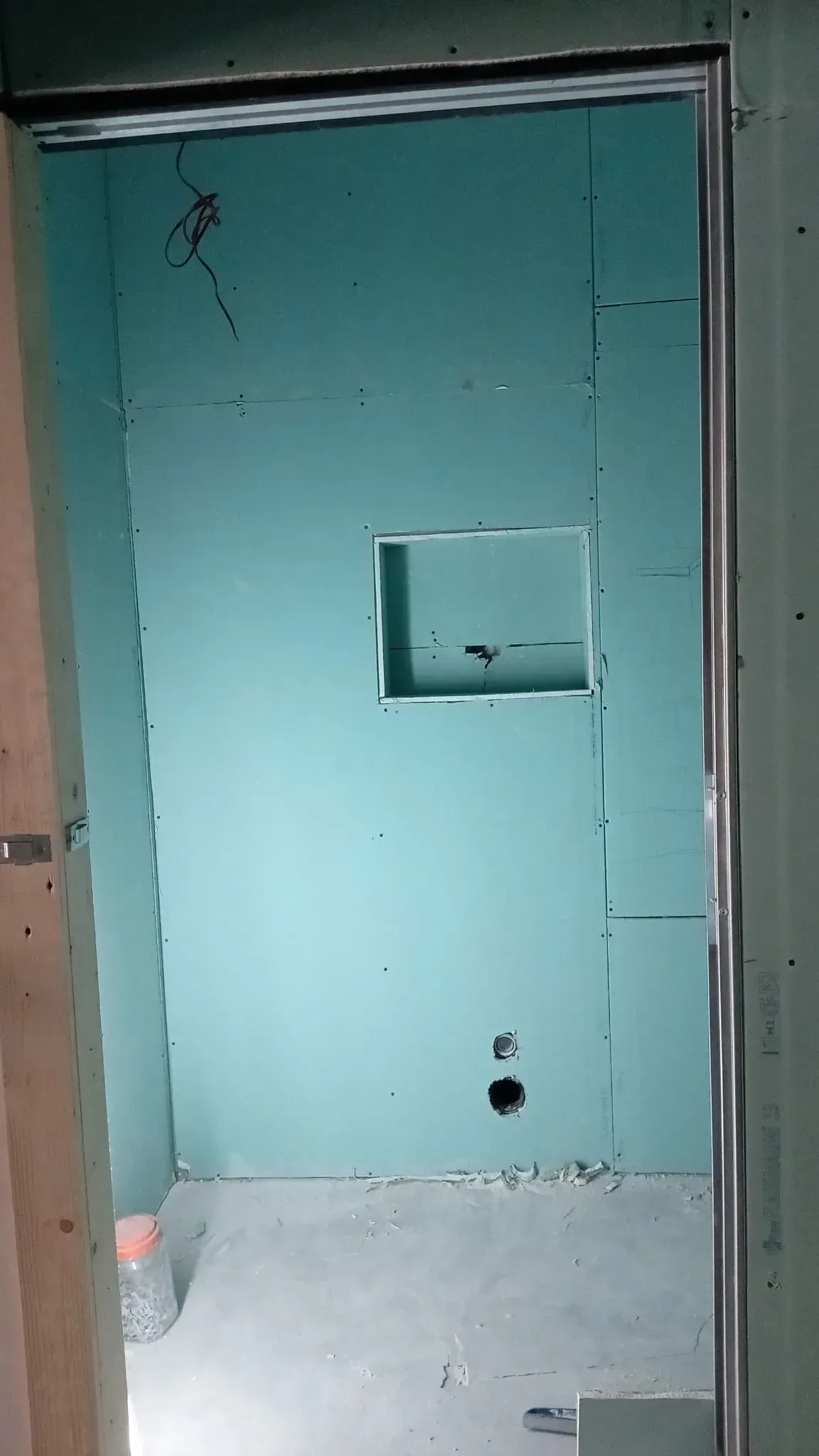 Pared de color turquesa con un pequeño estante empotrado