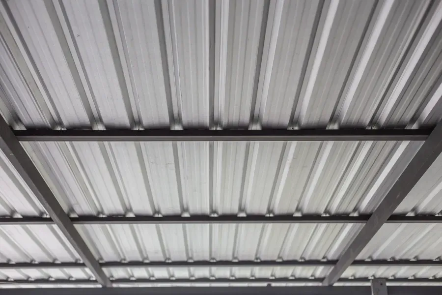 Primer plano de un techo de chapa ondulada metálica con vigas de soporte.