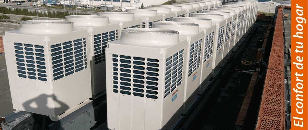 Una fila de aparatos de aire acondicionado blancos están alineados en un techo.