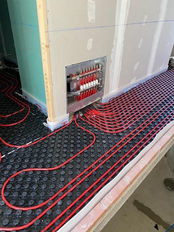 Un montón de cables rojos están conectados a una pared.