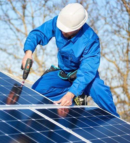 Un hombre está trabajando en un panel solar con un taladro.