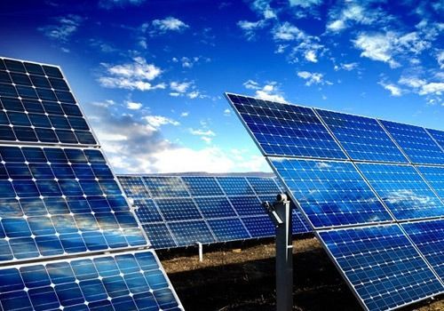 Una fila de paneles solares contra un cielo azul con nubes