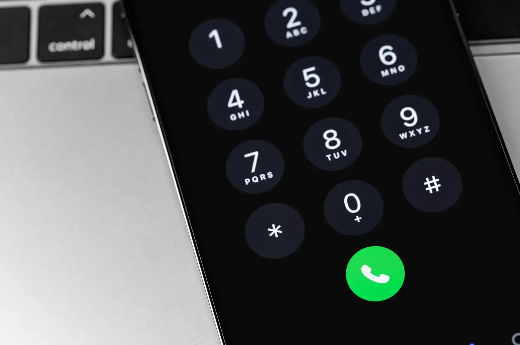 La pantalla de un teléfono inteligente muestra un teclado telefónico con un botón de llamada verde.