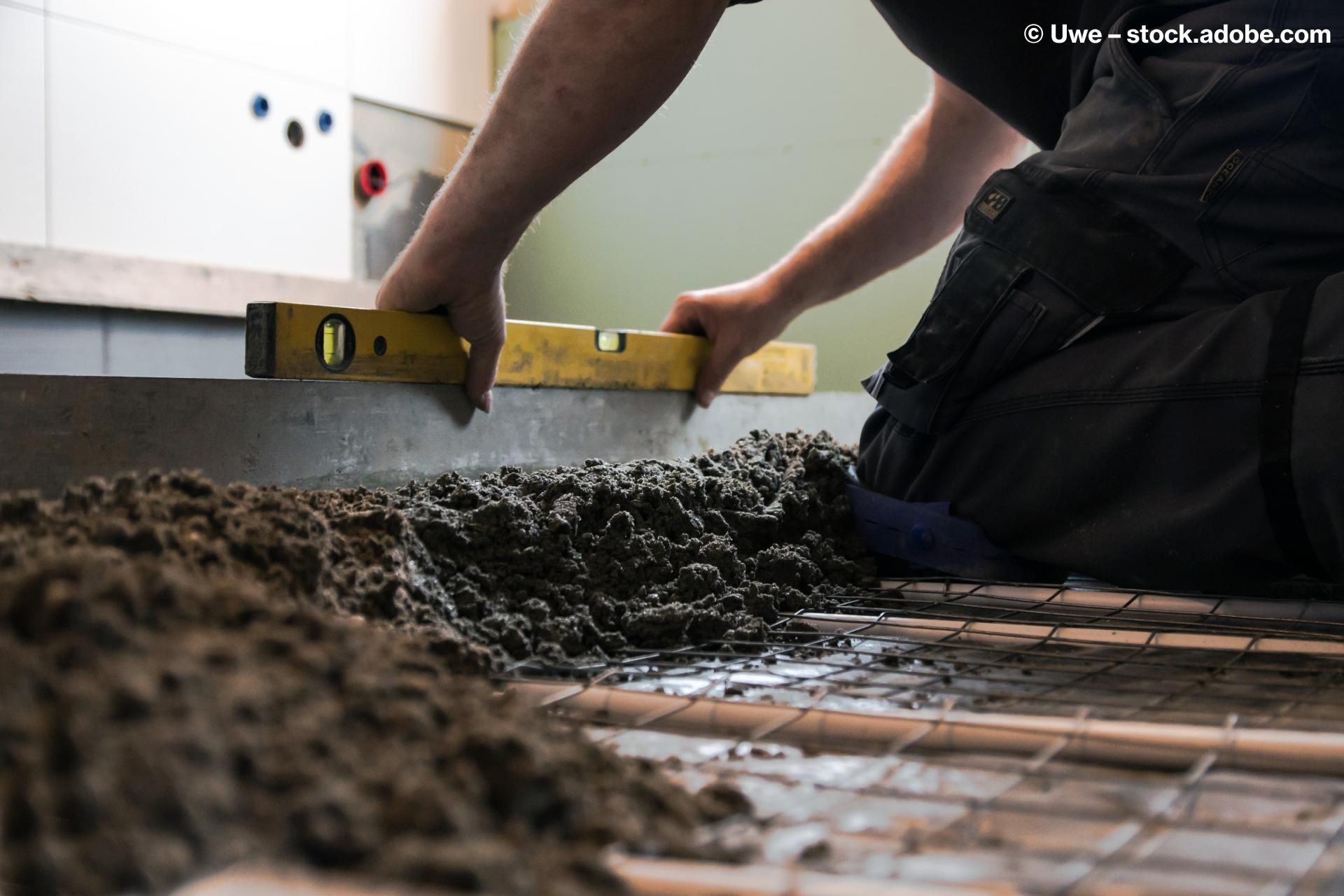 Bauarbeiter verlegt Estrichboden