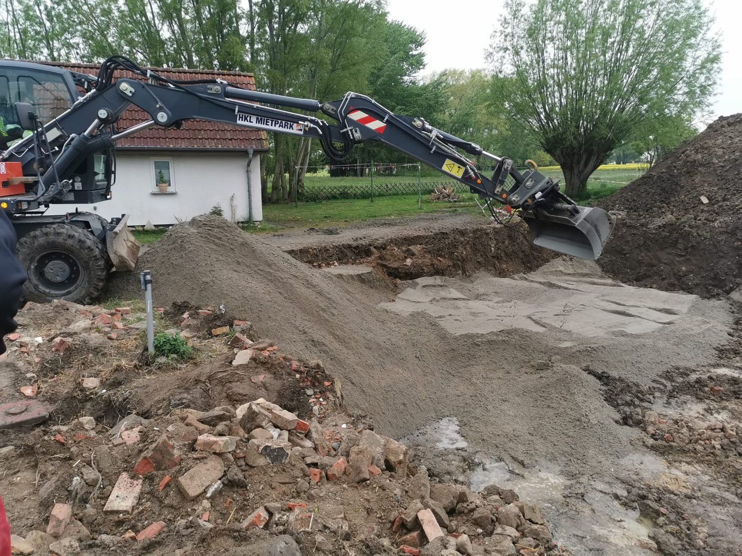 Ein Baggerarm, der eine Kuhle aushebt