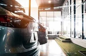 Una fila de coches están aparcados en una sala de exposición.