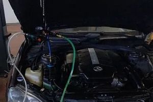 El capó de un coche está abierto y se está trabajando en el motor.