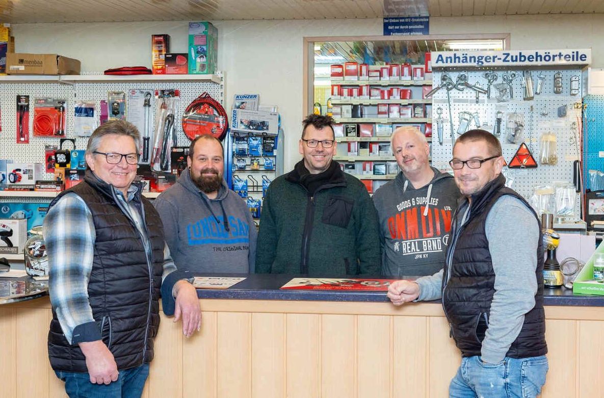 Eine Gruppe Männer steht vor einer Ladentheke.