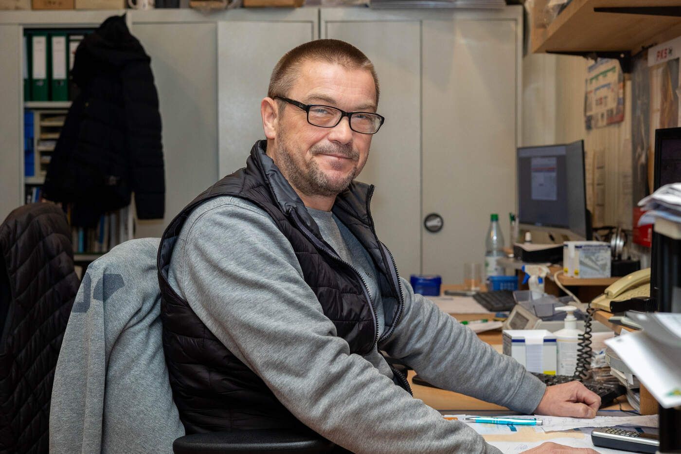 Ein Mann sitzt an einem Schreibtisch vor einem Computer.