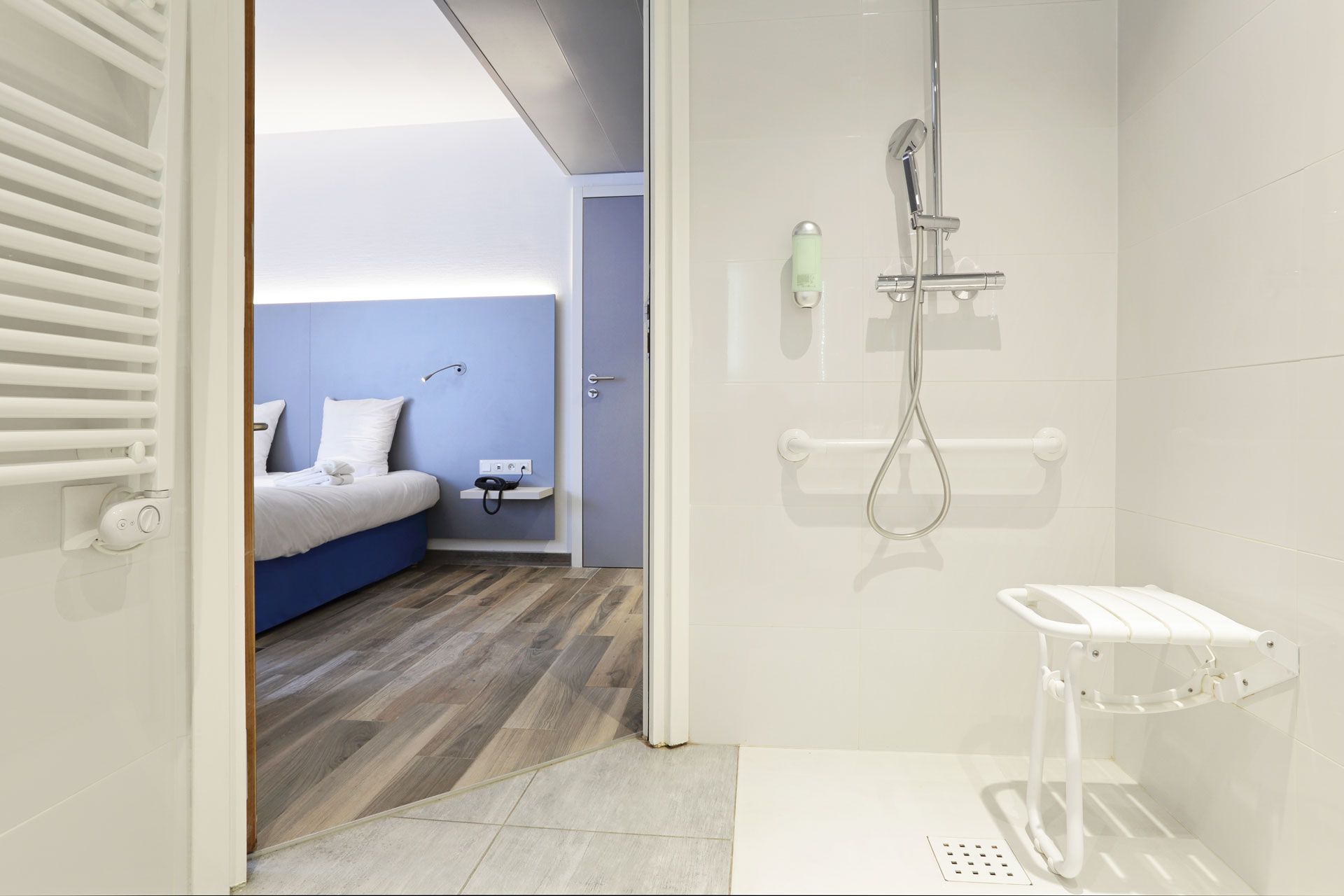 Une salle de bain ouverte sur une chambre aménagés pour les personnes à mobilité réduite
