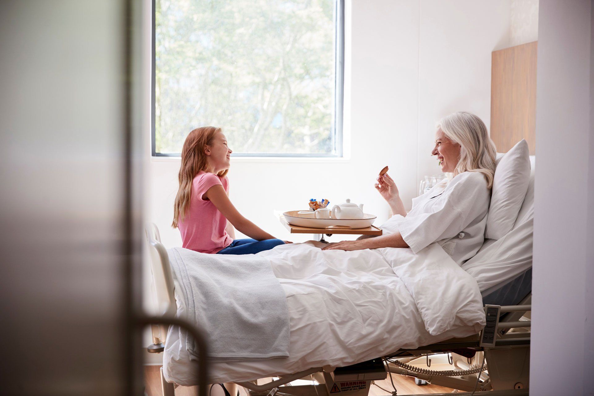 Une femme et un enfant dans une chambre sur un lit médicalisé