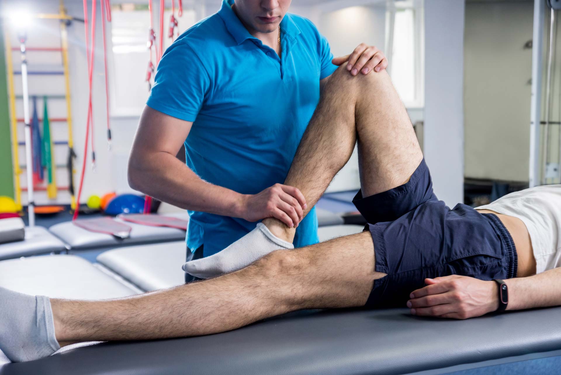 Un kinésithérapeute pratiquant sur la jambe d'un patient