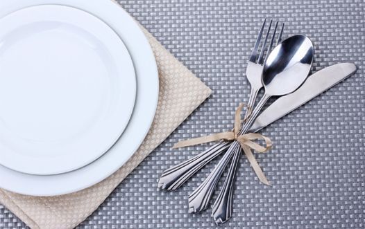 Un montón de cubiertos está atado con una cuerda sobre una mesa.