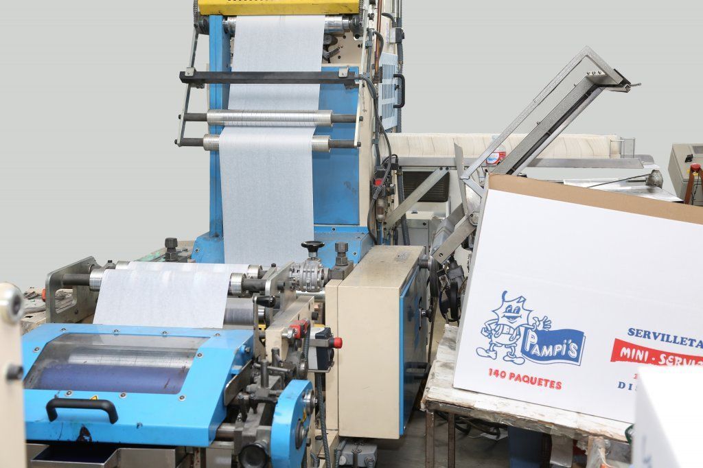 Una máquina está haciendo una caja de cartón con un logotipo en ella.
