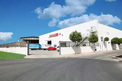 Un gran edificio blanco con un cartel rojo.
