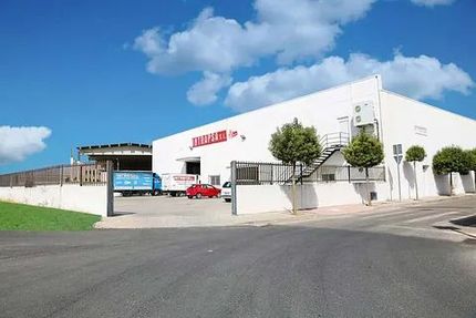 Un gran edificio blanco con un cartel rojo.