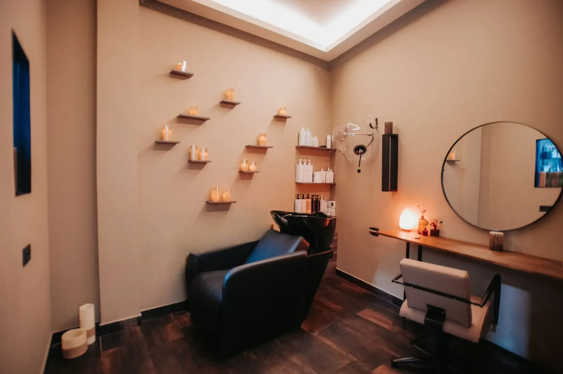 Mujer relajándose bajo la campana del spa; velas y flores de fondo.