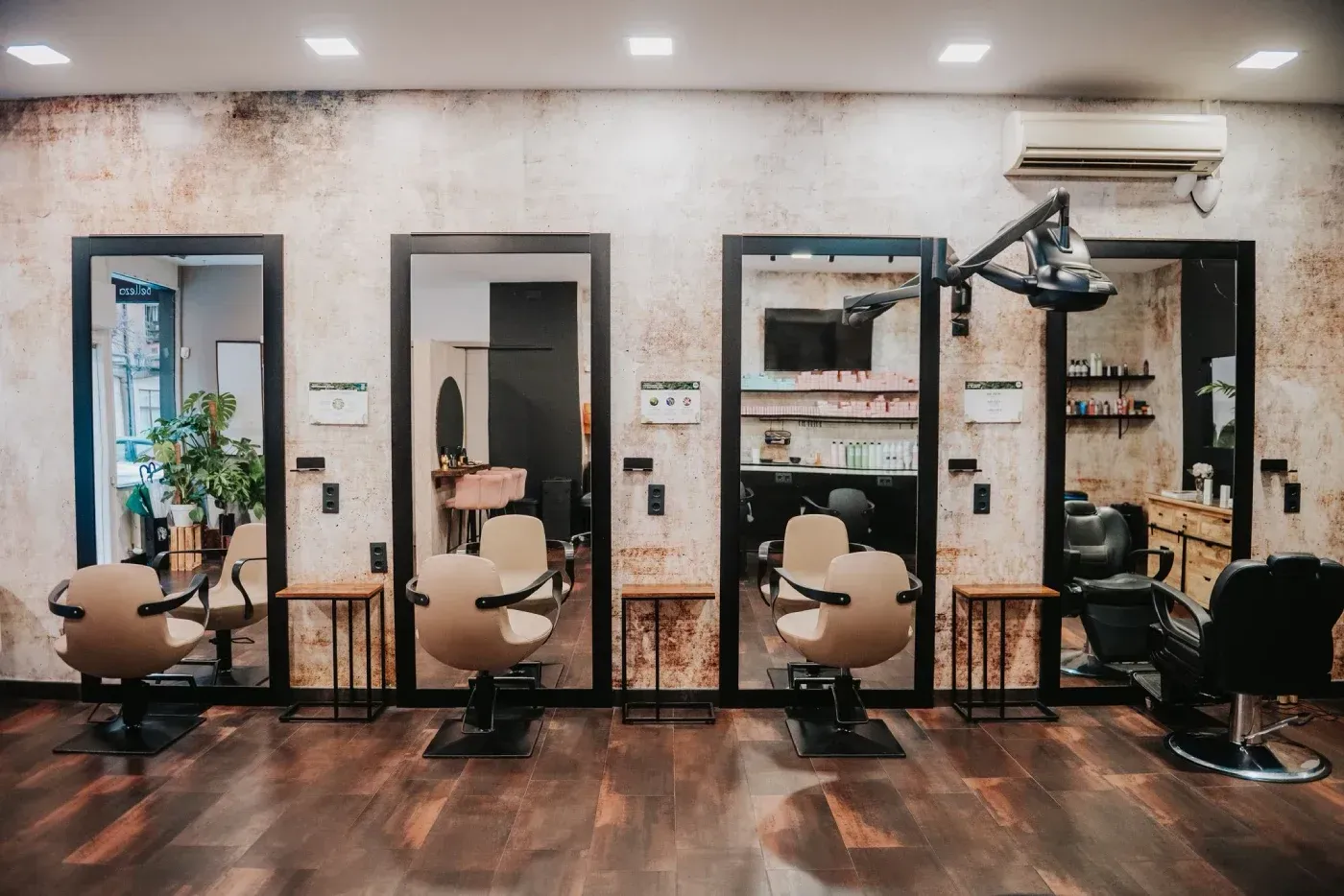Mujer con cabello rubio largo, ondulado y ombré, con falda de mezclilla, parada frente a una pared texturizada.