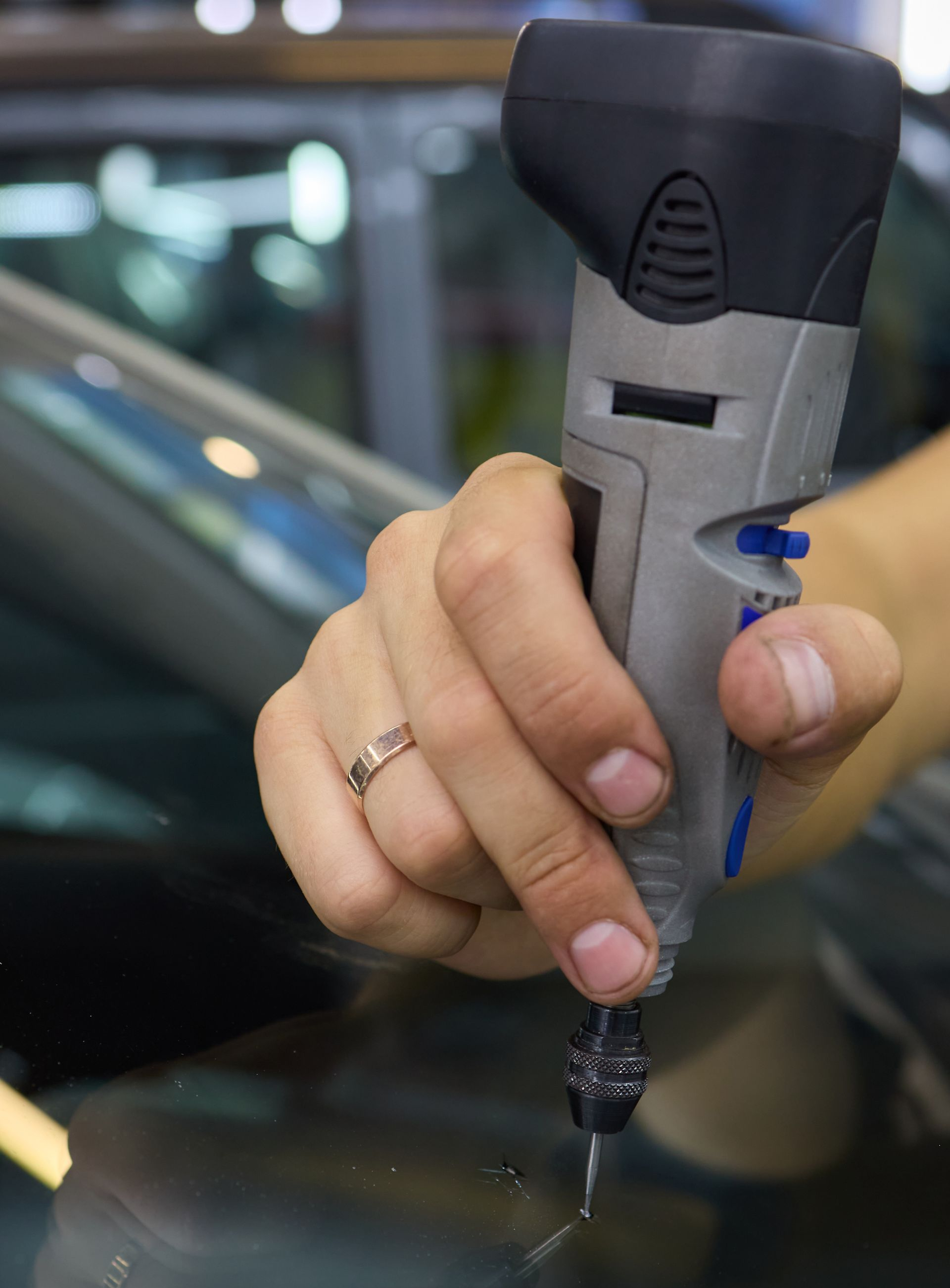 Personne utilisant un outil rotatif sur une surface en verre.