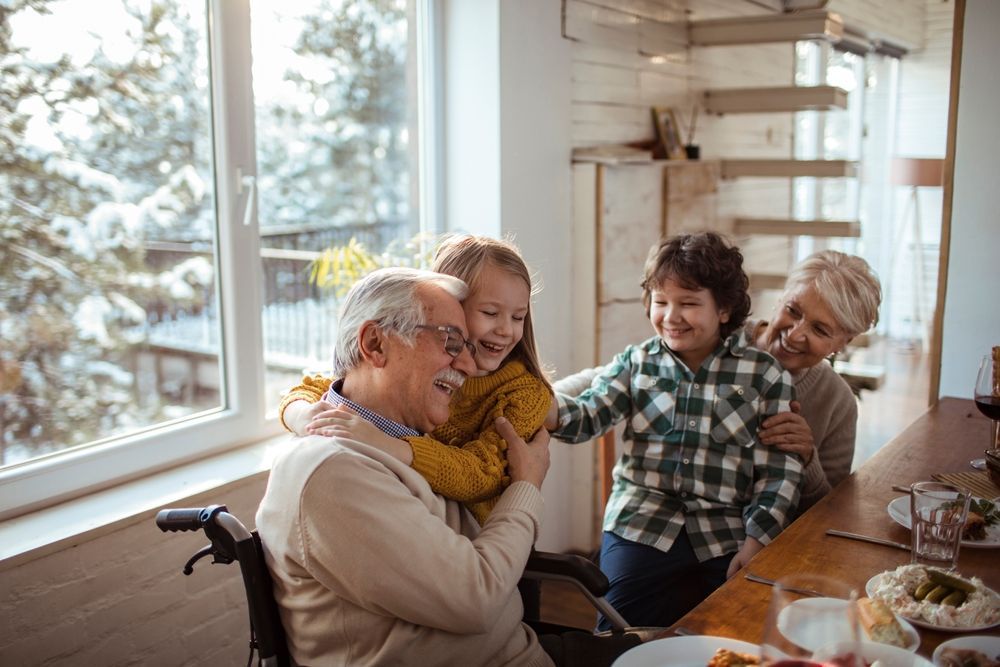La familia se reunió alrededor de la mesa del comedor, sonriendo y riendo en la luminosa cocina de su casa.