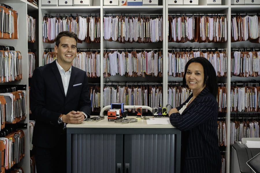 Deux collègues dans les archives du cabinet La Balme.